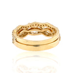 Gold ring with intricate design on a white background