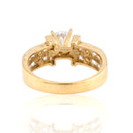Yellow gold engagement ring featuring a round brilliant cut center stone in a four-prong setting with a wide channel-set diamond band.