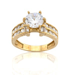 Gold ring with a large central diamond and smaller diamonds on the band against a white background