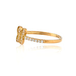 Gold ring with diamond accents on a white background