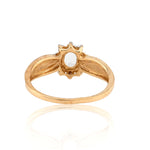 Gold ring with a central gemstone on a white background
