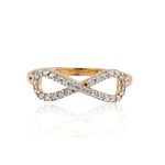 Gold and diamond infinity ring on a white background