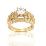Gold ring with a large central gemstone and smaller stones on a white background