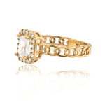 Gold ring with a central diamond and chain design on a white background