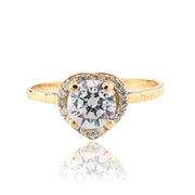 Gold ring with a large diamond and smaller diamonds around on a white background