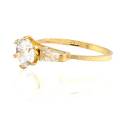 Gold ring with a clear gemstone on a white background