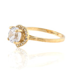 Gold ring with a clear gemstone on a white background