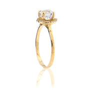 Gold ring with a clear gemstone on a white background