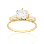 SB Jewelers' classic three-stone engagement ring in gold, featuring a high-brilliance round moissanite or diamond center and elegant baguette-cut side stones.