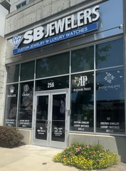 SB Jewelers store front with large glass windows and a blue sign.