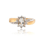 Gold ring with a central gemstone on a white background