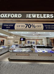 Oxford Jewelers store with jewelry display cases and promotional signs.