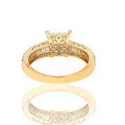 Gold ring with intricate design on a white background