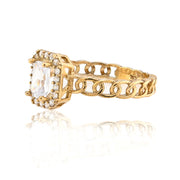 Gold ring with a central diamond and chain design on a white background