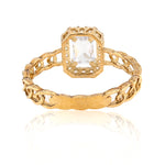 Gold ring with a clear gemstone on a white background