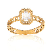 Gold ring with a clear gemstone on a white background