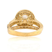 Gold ring with a central gemstone on a white background