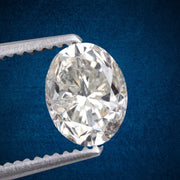 Diamond held in tweezers against a blue background